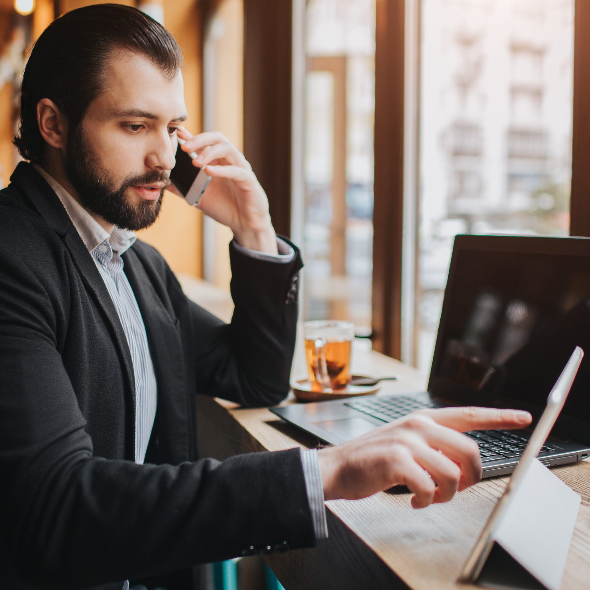 Busy man is in a hurry, he does not have time, he is going to eat snack on the go. Worker eating, drinking coffee, talking on the phone, at the same time. Businessman doing multiple tasks. Multitasking business person.